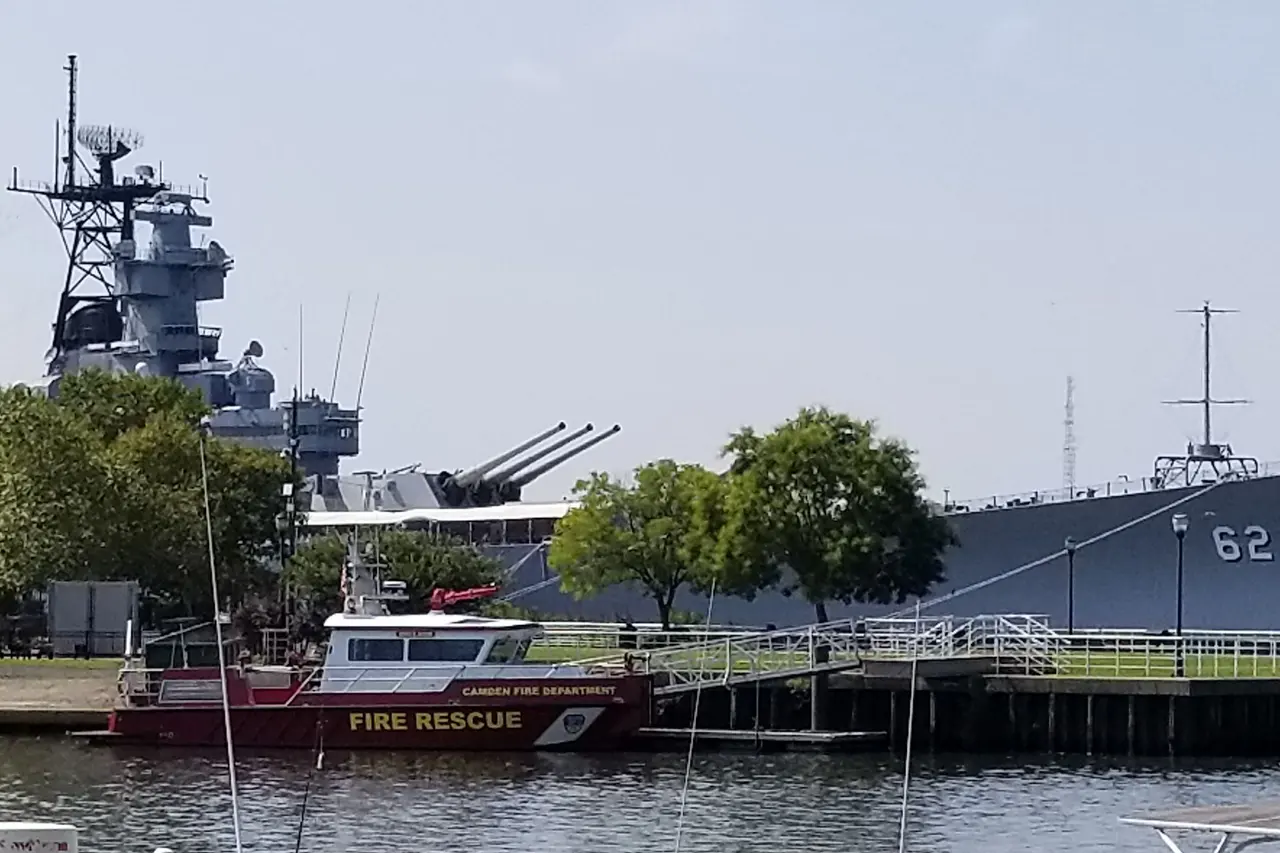 The battleship New Jersey moored on the Camden waterfront, behind a Camden fire rescue boat